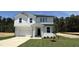 Charming two-story home with white siding, a well-manicured lawn, and an attached garage at 147 Gobbler Dr, Smithfield, NC 27577