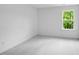 Bright bedroom featuring neutral carpet, fresh white walls, and a window offering views of the lush green surroundings at 174 Hickory Grove Dr, Sanford, NC 27330