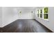Spacious living room with dark hardwood floors and multiple windows letting in natural light and a view of the backyard at 174 Hickory Grove Dr, Sanford, NC 27330