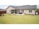 Backyard view featuring a covered patio, grill, and ample lawn space at 18 Fisher Rd, Lillington, NC 27546