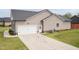 Spacious driveway leading to a two-car garage, complemented by lush green lawn at 18 Fisher Rd, Lillington, NC 27546