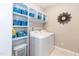 Functional laundry room featuring a washer, dryer, shelving, and storage baskets at 18 Fisher Rd, Lillington, NC 27546