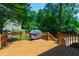 Large wooden deck featuring a grill, overlooking a tree-filled yard; ideal for outdoor gatherings at 1816 Albacore Ln, Raleigh, NC 27612