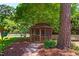 Charming wooden gazebo nestled in a lush backyard, surrounded by trees and landscaping at 1816 Albacore Ln, Raleigh, NC 27612