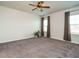 Spacious bedroom with plush carpet, a ceiling fan, and sunlit windows dressed with tasteful curtains at 1941 Bright Kannon Way, Wendell, NC 27591
