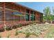 A modern farmhouse-style building with wood accents and colorful flowerbeds surrounding the entryway at 1941 Bright Kannon Way, Wendell, NC 27591