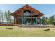 A modern farmhouse-style exterior view showcasing outdoor seating, umbrellas, and lush landscaping at 1941 Bright Kannon Way, Wendell, NC 27591