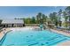 A community pool area with a slide, splash pad, lounge chairs, and lush green surroundings at 1941 Bright Kannon Way, Wendell, NC 27591