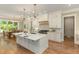 Beautiful kitchen features a large island, modern appliances, wood floors, and luxury light fixtures at 2016 Falls Forest Dr, Raleigh, NC 27615
