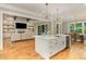 Bright kitchen features a large island, wooden floors, open to the living room, and luxury light fixtures at 2016 Falls Forest Dr, Raleigh, NC 27615