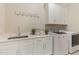 Bright laundry room with a utility sink, storage cabinets, washer, and dryer at 2016 Falls Forest Dr, Raleigh, NC 27615