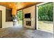 Covered patio features outdoor kitchen with grill, fireplace, TV and bluestone tile floors at 2016 Falls Forest Dr, Raleigh, NC 27615