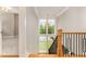 Elegant staircase with oak treads and black iron railing, illuminated by a two story window and chandelier at 2016 Falls Forest Dr, Raleigh, NC 27615
