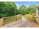 Wooden deck with railings overlooking the backyard with a pool and mature trees at 205 Smiths Creek Dr, Clayton, NC 27520