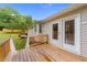Wooden deck with railings overlooking the landscaped backyard and patio area at 205 Smiths Creek Dr, Clayton, NC 27520