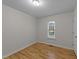 This bedroom features light-colored walls, wood-look laminate flooring and a window at 205 Smiths Creek Dr, Clayton, NC 27520