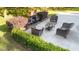 Outdoor patio with fireplace, wicker seating, glass table, and manicured landscaping at 205 Smiths Creek Dr, Clayton, NC 27520