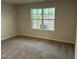 Bedroom with carpeted floors featuring a view of a wooded area and new construction at 2118 Terrawood Dr, Durham, NC 27703