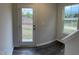 Hallway with dark wood-look floors leading to a white door with view of wooded area at 2118 Terrawood Dr, Durham, NC 27703