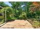 Backyard showcasing a wooden deck surrounded by lush greenery, mature trees, and serene landscaping at 2143 Ridge Rd, Raleigh, NC 27607