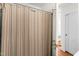 Bathroom featuring a shower with striped curtain, white walls, and door frame with a wood door at 2143 Ridge Rd, Raleigh, NC 27607