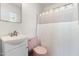 Bathroom featuring light pink toilet, white sink, and a shower with curtain at 2143 Ridge Rd, Raleigh, NC 27607