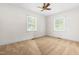 Bright bedroom features neutral walls, ceiling fan, and two windows offering natural light and outdoor views at 2143 Ridge Rd, Raleigh, NC 27607