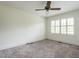 Bright bedroom with neutral carpet, ceiling fan, and a window with white shutters at 2143 Ridge Rd, Raleigh, NC 27607