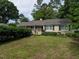 Lovely exterior of a tan home featuring green shutters and a well-kept lawn at 2143 Ridge Rd, Raleigh, NC 27607