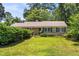Traditional home featuring a green lawn, mature landscaping, and classic shutters at 2143 Ridge Rd, Raleigh, NC 27607