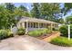 Home with charming front porch, landscaped garden, brick path, and gated entrance at 2143 Ridge Rd, Raleigh, NC 27607