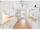 Bright kitchen featuring white cabinetry, tan countertops, tile flooring, and modern appliances at 2143 Ridge Rd, Raleigh, NC 27607