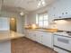 Traditional kitchen featuring white cabinets, tile floors, and standard appliances at 2143 Ridge Rd, Raleigh, NC 27607