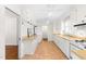 Bright kitchen featuring white cabinetry, tan countertops, tile flooring, and modern appliances at 2143 Ridge Rd, Raleigh, NC 27607