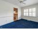 Living room with blue carpet, white walls, and view into kitchen at 2143 Ridge Rd, Raleigh, NC 27607