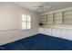Living room with built-in cabinets and shelves, and blue carpet at 2143 Ridge Rd, Raleigh, NC 27607