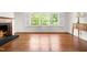Bright living room featuring hardwood floors, a fireplace, and large windows at 2143 Ridge Rd, Raleigh, NC 27607