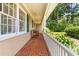 Relaxing covered porch with red brick floor and views of the lush garden at 2143 Ridge Rd, Raleigh, NC 27607