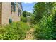 Brick home featuring a charming, overgrown brick pathway to a white fence, surrounded by lush greenery at 2143 Ridge Rd, Raleigh, NC 27607