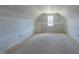 Attic space with unfinished walls and a window offering natural light, showing potential for customization at 25 Sanders Farm Dr, Smithfield, NC 27577