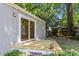 The backyard patio includes a sliding glass door entrance to the house and is surrounded by trees and green space at 2823 Fowler Ave, Raleigh, NC 27607