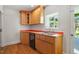 Cozy kitchen features wooden cabinets, stainless steel sink, and view to the backyard at 2823 Fowler Ave, Raleigh, NC 27607
