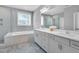 Bright bathroom featuring a glass shower, garden tub, and double vanity at 2848 Angelica Rose Way, Apex, NC 27502