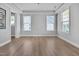 Bright room with light hardwood flooring, tray ceiling, and many windows at 2848 Angelica Rose Way, Apex, NC 27502