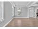 Bright room with light hardwood flooring, tray ceiling, and many windows at 2848 Angelica Rose Way, Apex, NC 27502