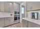 Contemporary kitchen with gray cabinetry, stainless steel appliances, and undermount microwave at 2848 Angelica Rose Way, Apex, NC 27502