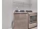 Modern laundry room featuring front load washer and dryer with overhead storage shelves at 2848 Angelica Rose Way, Apex, NC 27502