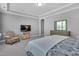 Serene main bedroom featuring a patterned accent chair, light gray walls and carpeting, and a dresser with a mirror at 2848 Angelica Rose Way, Apex, NC 27502
