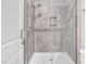 Walk in shower with gray tile, glass enclosure, and a hand held shower fixture at 2848 Angelica Rose Way, Apex, NC 27502