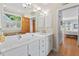 This bathroom features a double sink vanity, large mirror, and neutral color palette at 30119 Settle, Chapel Hill, NC 27517